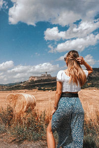 Woman standing on field against sky