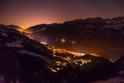 Scenic view of illuminated mountains against sky at night