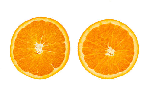 Close-up of orange slices over white background