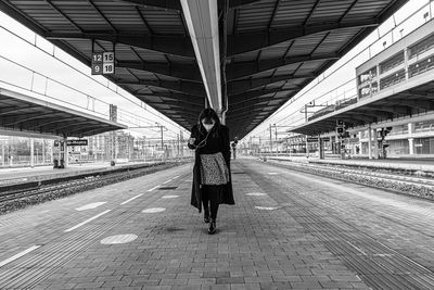 Rear view of people walking on railroad station