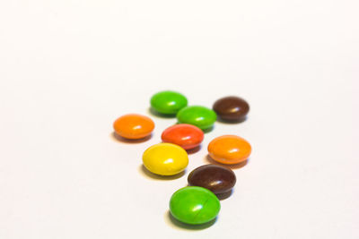 High angle view of multi colored balls on white background