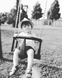 Portrait of cute boy swinging at park