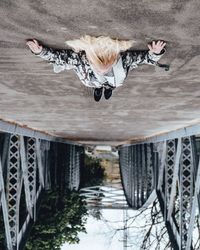 Upside down image of woman lying on bridge