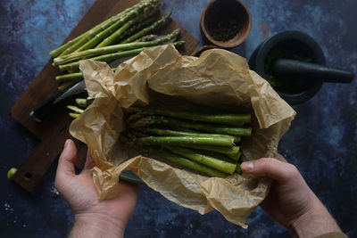 Hands holding fresh asparagus grillled in the oven