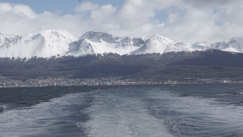 Scenic view of snowcapped mountains and sea against sky