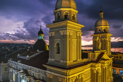 Low angle view of illuminated buildings against sky at dusk