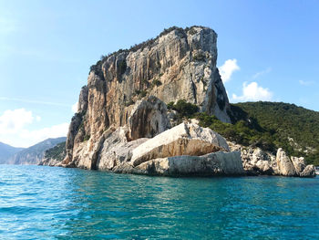 Scenic view of rock formation in sea against sky