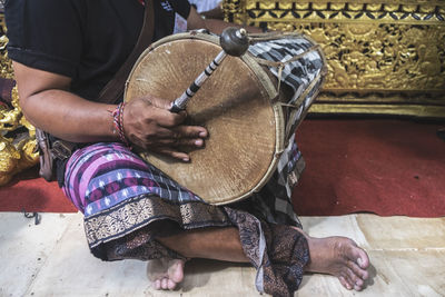 Low section of man playing tabla on floor