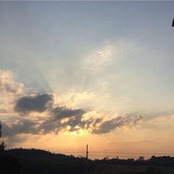 Silhouette of landscape against cloudy sky