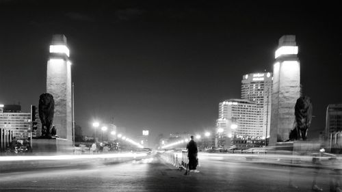 People on illuminated street at night