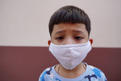 Cute asian boy wearing mask to protect pandemic corona virus or covid-19 with concern, copy space.