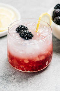 Bramble cocktail garnished with blackberries and a lemon wheel.