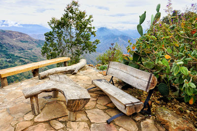 Wooden table and mountains against sky