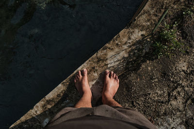 Low section of man standing in water