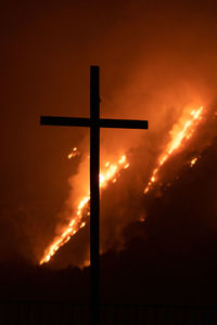 Low angle view of silhouette cross against sky at sunset