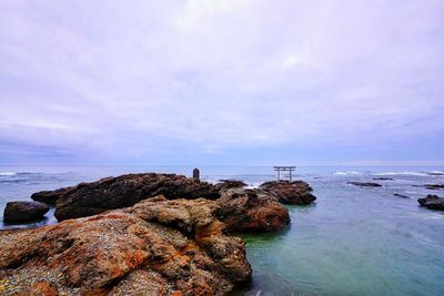 Rocks in sea against sky