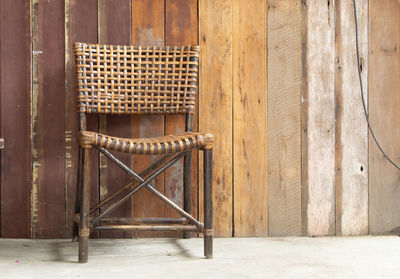 Empty chairs and table against wall in old building