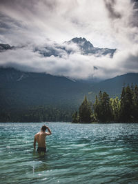 Man swimming in lake against sky