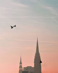 Low angle view of silhouette birds flying against sky