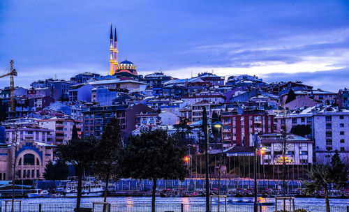 Illuminated buildings in city at dusk