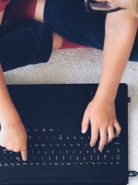 Midsection of child using laptop at home