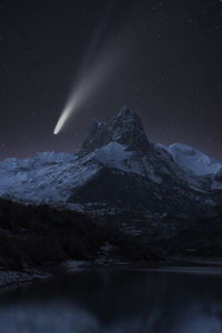 Scenic view of snowcapped mountains against sky at night