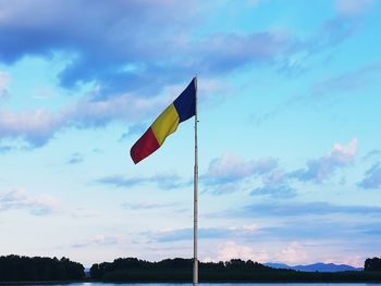 Low angle view of flag against blue sky