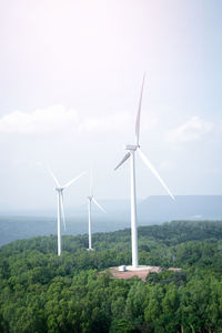 Windmills on landscape against sky