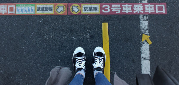 Low section of man standing by signs on road