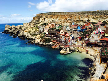 Aerial view of sea and buildings against sky