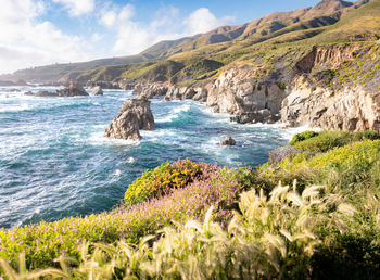 Scenic view of sea and mountains against sky