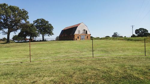 Barn on field against clear sky