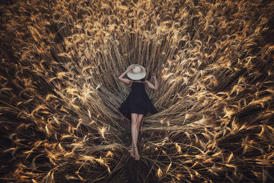 Rear view of woman standing amidst plants