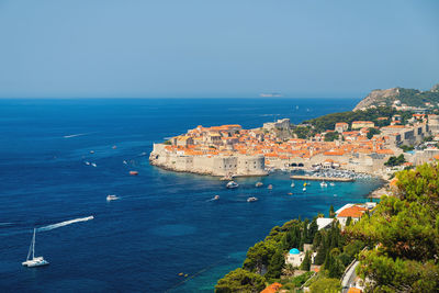 High angle view of townscape by sea against clear sky