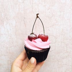 Close-up of fingers holding cupcake