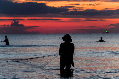 A fisherman is fishing at sunset on koh rong, cambodia