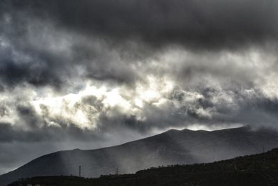 Scenic view of mountains against cloudy sky