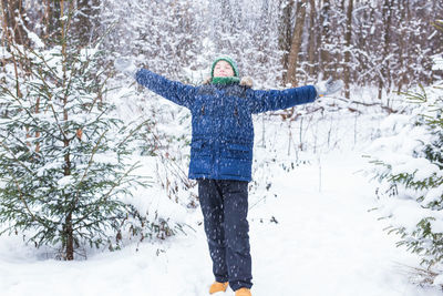 Person standing by snow covered land