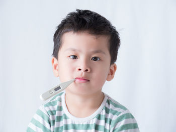 Portrait of boy holding white indoors