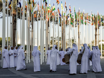 A group of emirati dancing a traditional dance wearing traditional clothes at expo dubai 2020. 