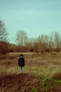 Rear view of man with mask walking on field