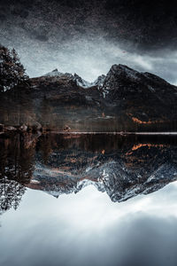 Scenic view of lake by snowcapped mountains against sky