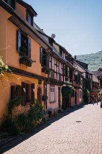 Houses by street in town against sky