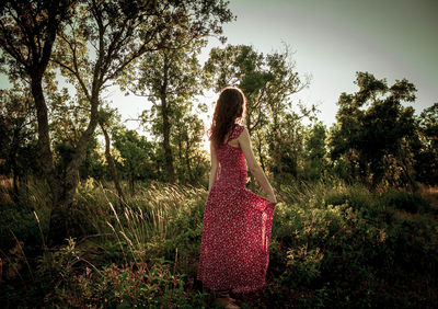 Young woman in the middle of a forest in long summer dress