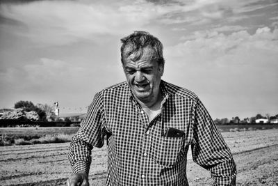 Senior man walking on land against sky