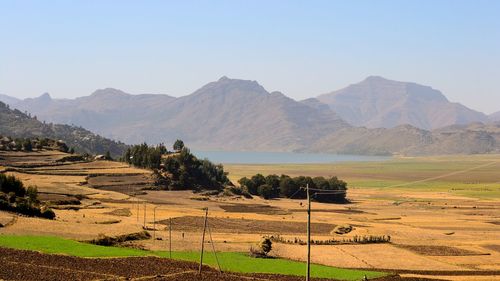 Scenic view of field and mountains against clear sky