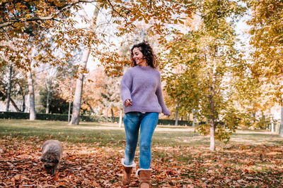 Full length of woman with dog at park during autumn