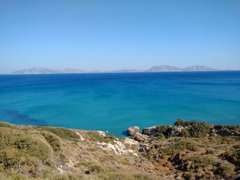 Scenic view of sea and hill against sky