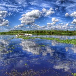 Scenic view of lake against cloudy sky