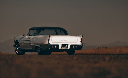 Vintage car on field against clear sky